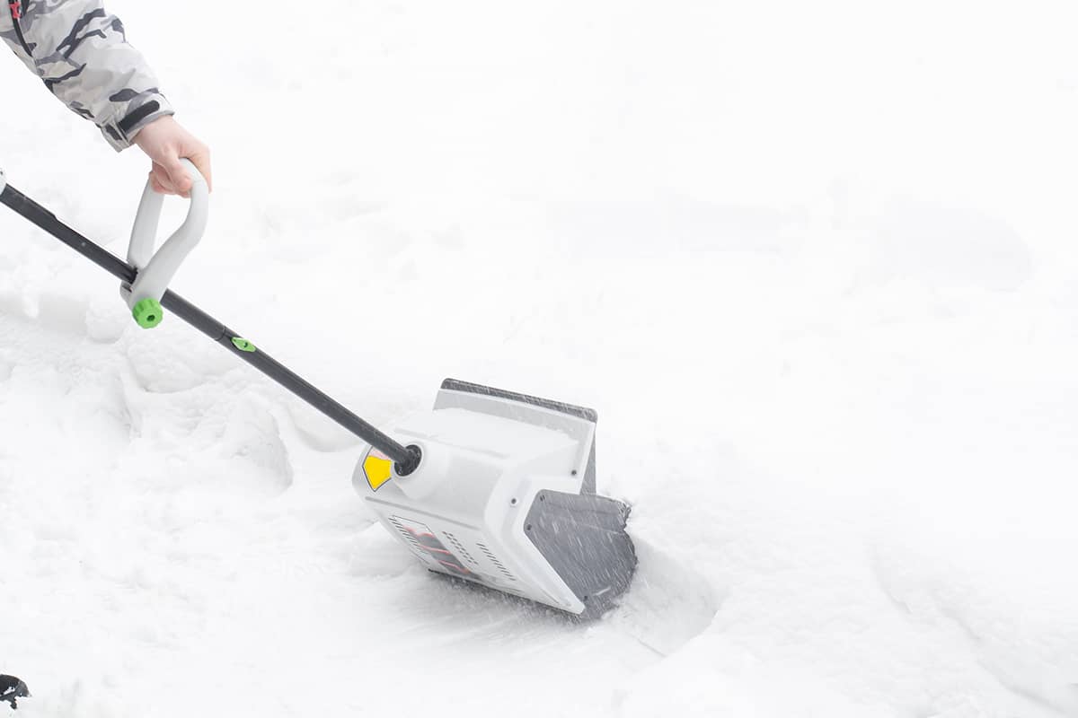 Man removing snow using snow removal device