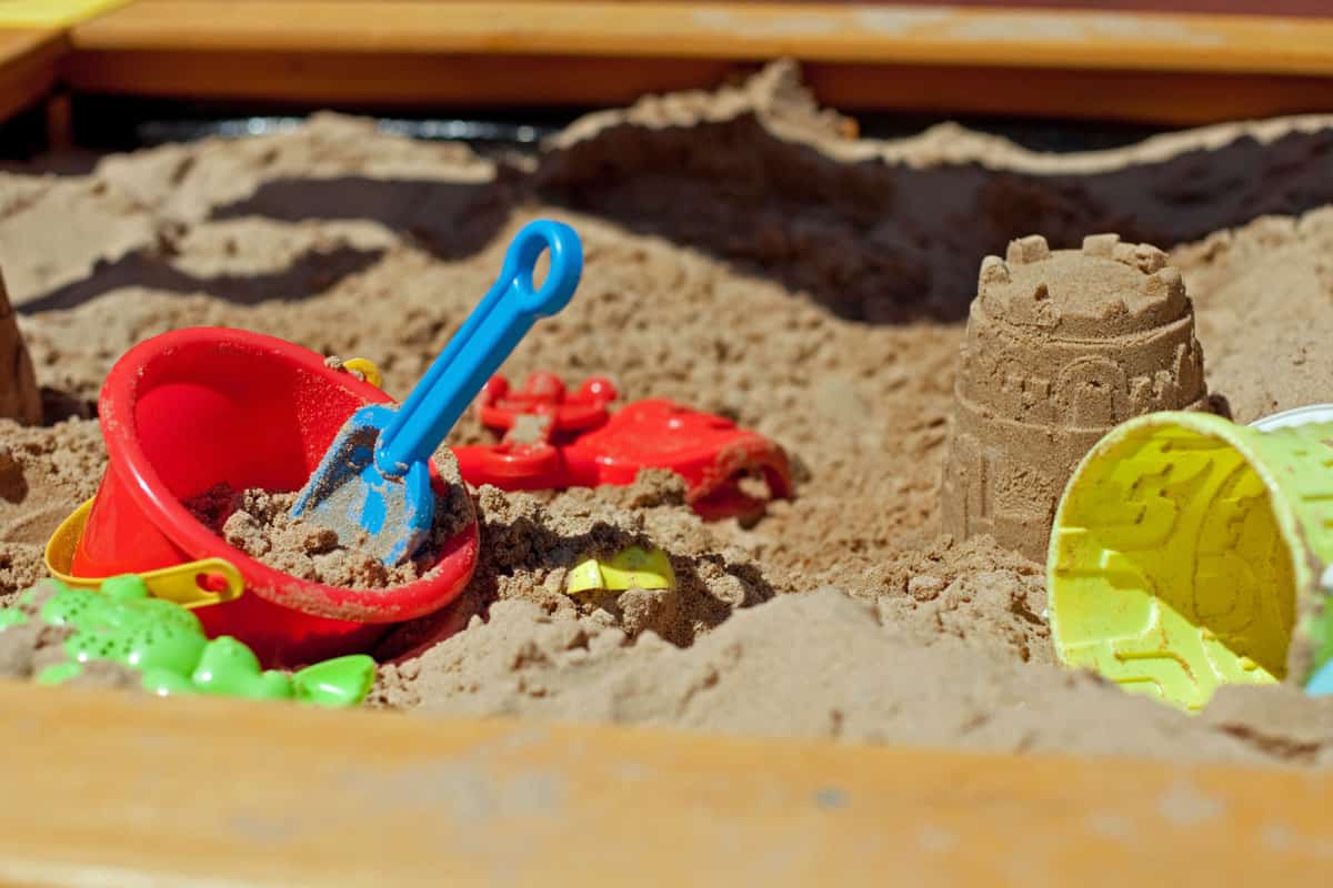Playing sand with toys scattered all around