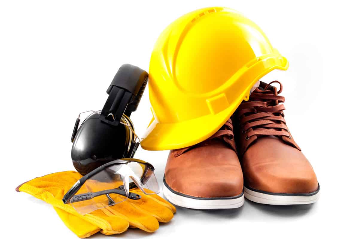 Work safety concept with hard hat, protective gloves, boots, eye safety glasses and hearing protecting noise canceling earmuffs