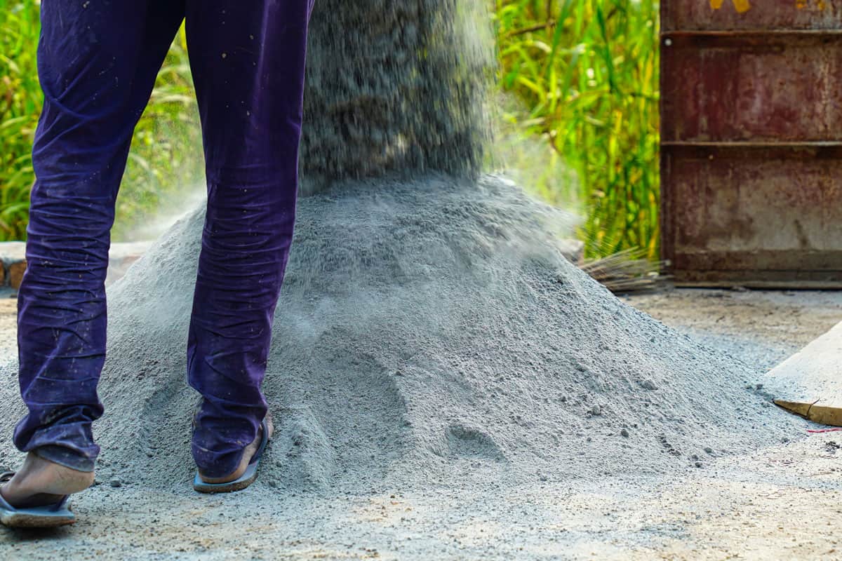labour put down cement on ground for making concrete paste