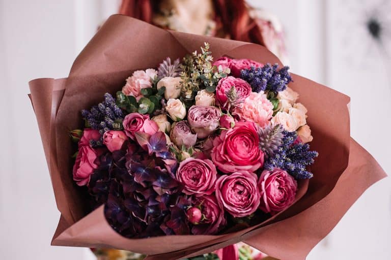 Very nice young woman holding big and beautiful bouquet, Celebrities And Influencers Go All Out With These Thousand-Dollar Blooms—Are They Worth It?
