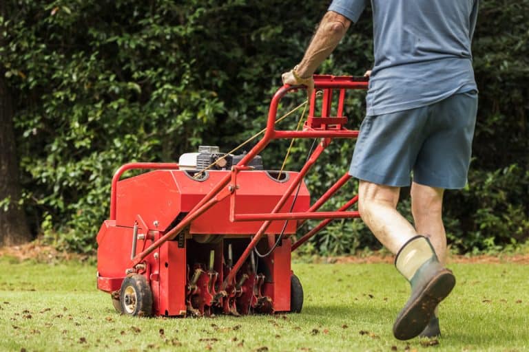 Man using gas powered aerating machine to aerate residential grass yard, How To Start A TA18 Aerator [Step By Step Guide]