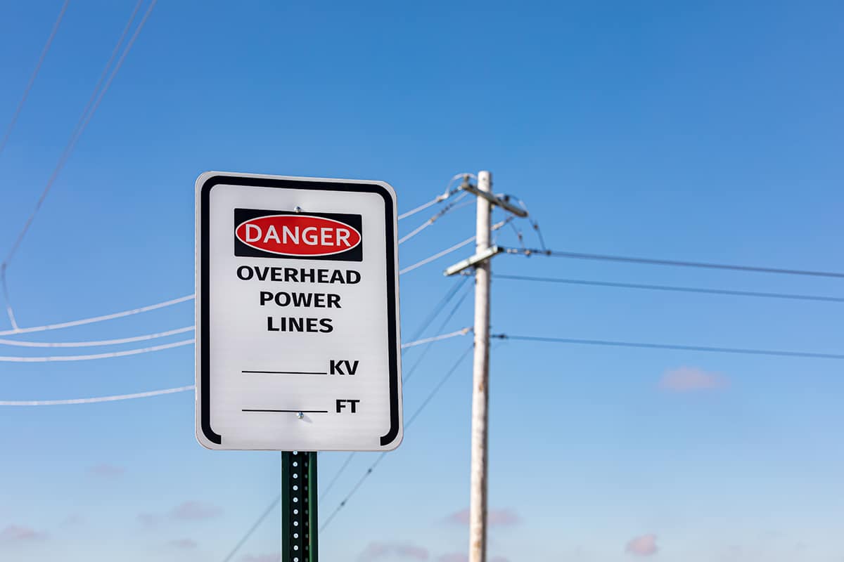 Road sign warning of overhead power lines danger