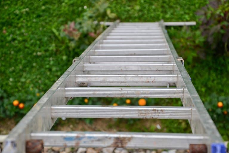 Top view of a long silver aluminum ladder leaning against the wall of the house, Electrifying Danger: The Truth About Aluminum Ladders and Lightning