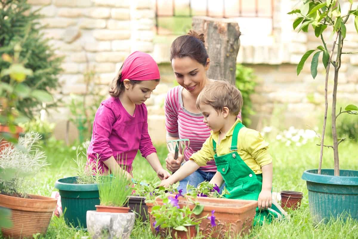 Young mother gardening in front or back yard with her two cute little children, 15 Tips for Cultivating a Love of Gardening in Children