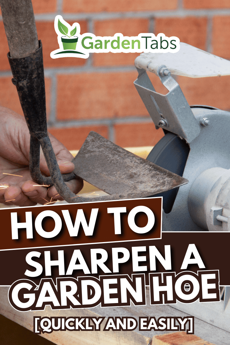 mans hand sharpens a hoe on electric grindstone in rural shed.