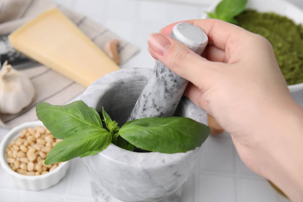Crushing basil in a mortar and pestle