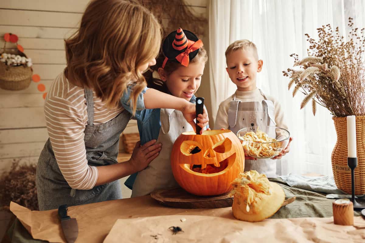 Kids having fun carving a pumpkin for Halloween