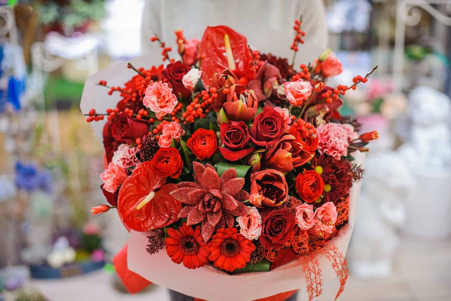 Bright and gorgeous bouquet of lovely red flowers in woman hands