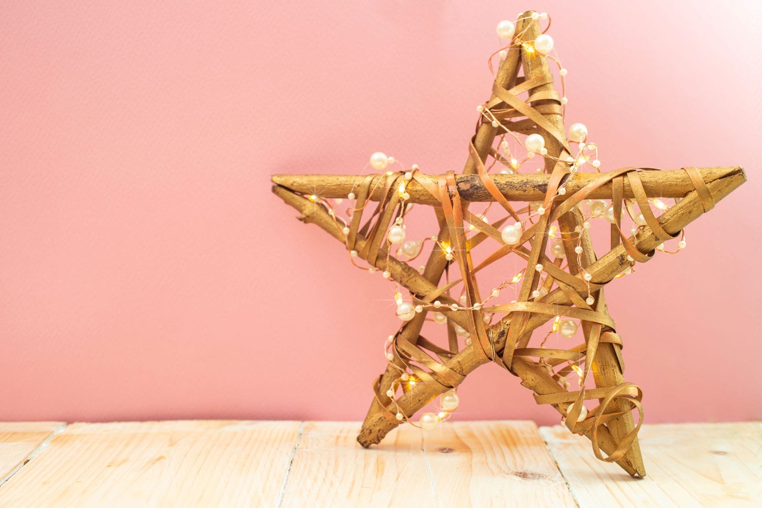 branches or twigs star, hand made, with christmas lights on pink background