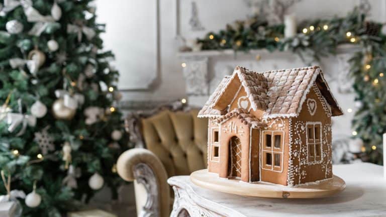 A small gingerbread house placed in the living room close to the christmas tree, Edible Decorations Grow and Make Your Own Gingerbread House Decor - 1600x900