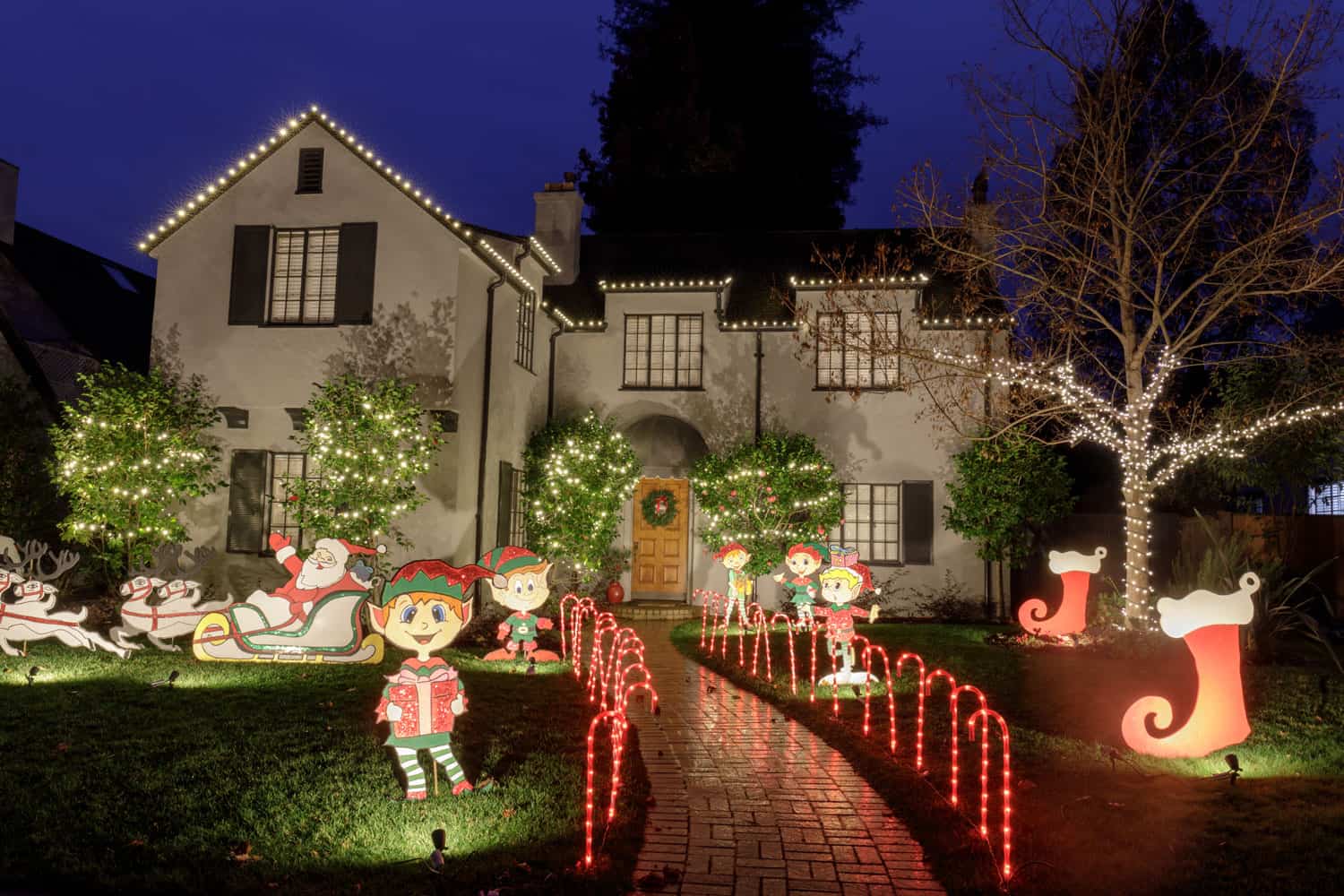 A stone mansion with Christmas decorations up front