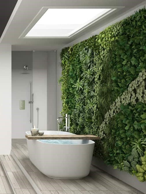 A modern bathroom featuring a freestanding bathtub with an adjacent lush vertical garden of succulents and leafy plants on one wall, lit by natural light from an overhead skylight ar 3:4