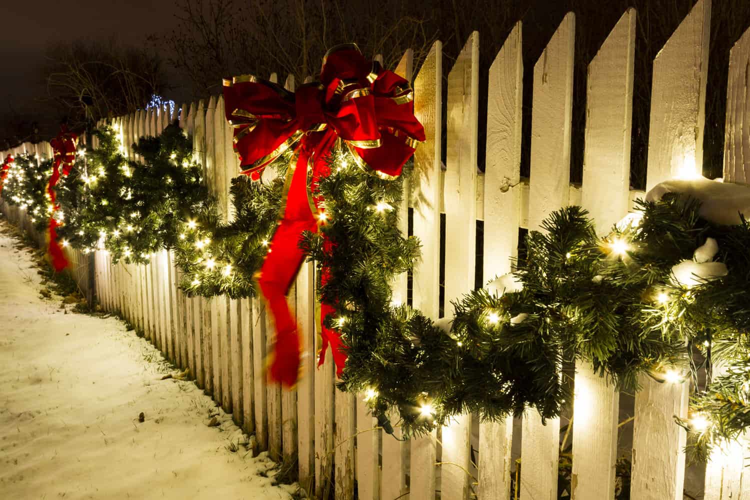 A beautiful fence decorated with Garlands and Christmas lights