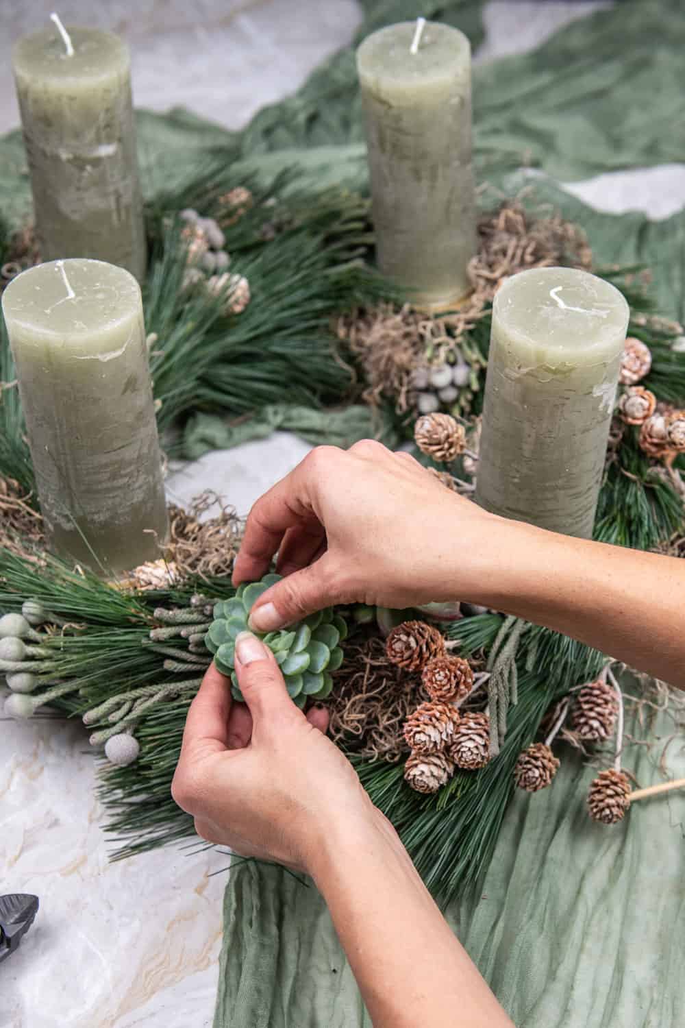 Woman making a gorgeous wreath with candles and succulents