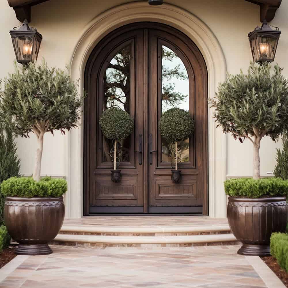 Tuscan-Inspired mahogany front door with Potted olive trees and evergreen trees